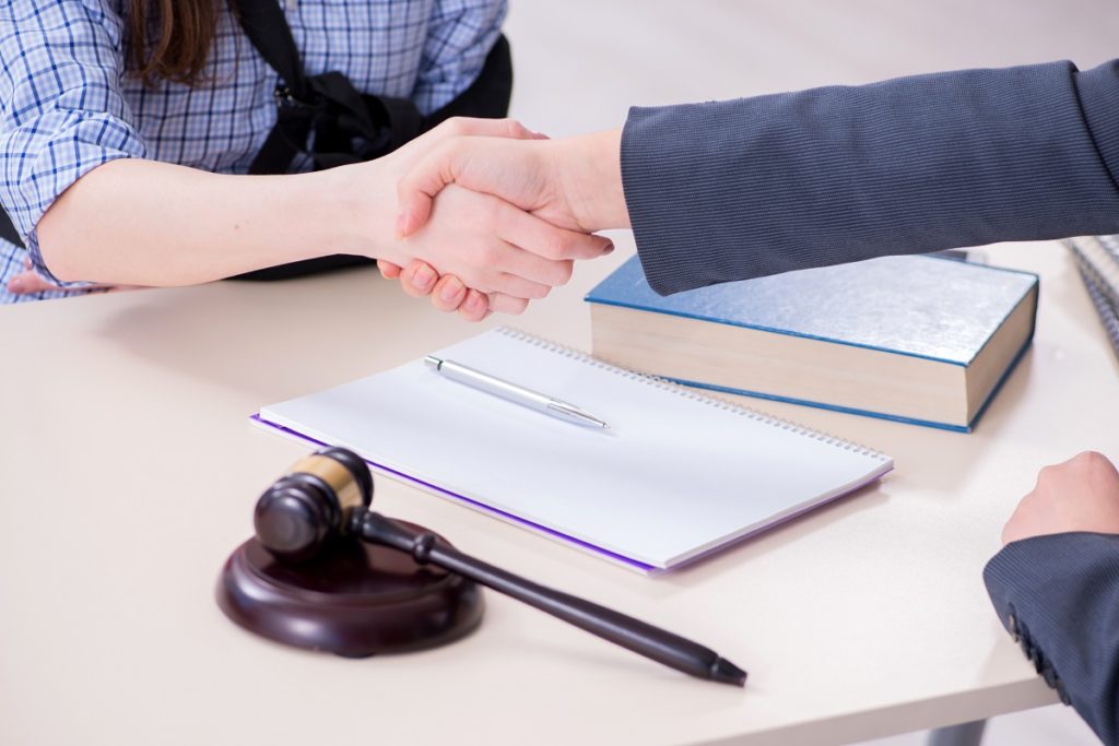 Injured client shaking hands with her lawyer