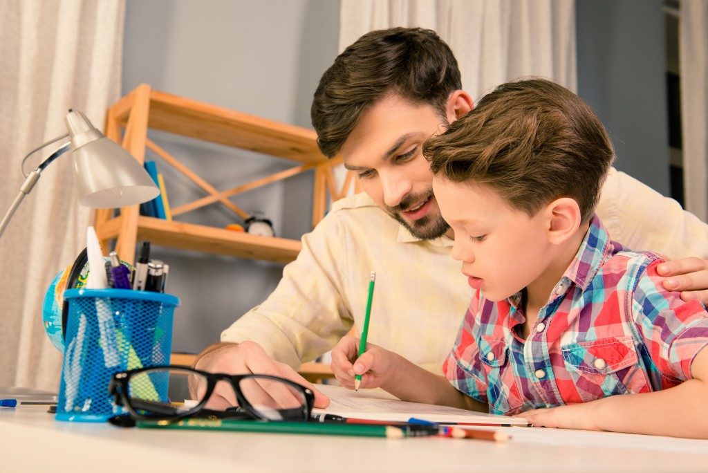 Dad encouraging his son in writing