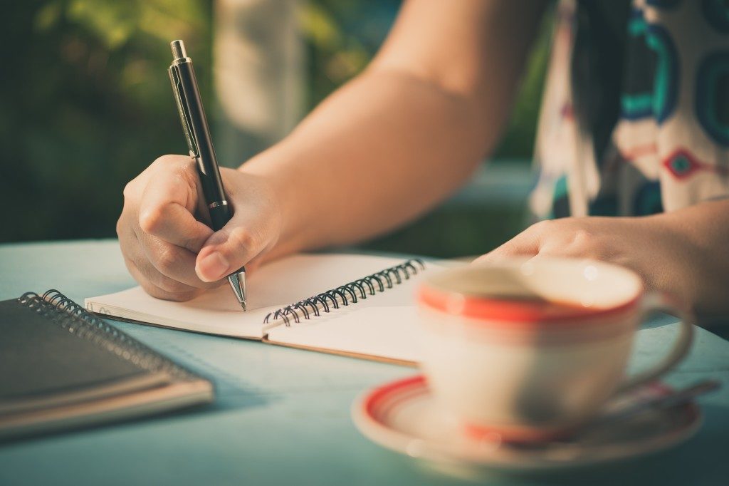 Woman hand writing on journal