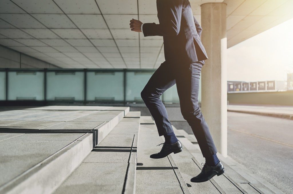 Man in business attire going up the stairs