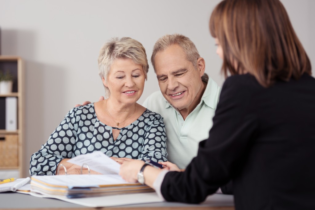 senior couple talking to a real estate broker