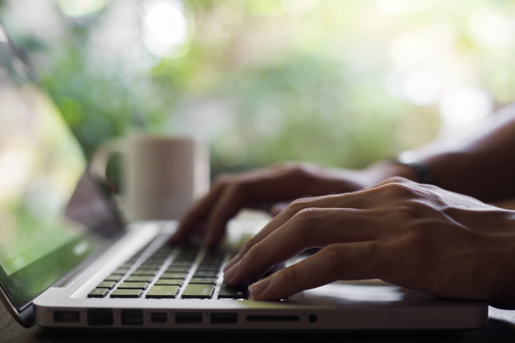 man typing on a laptop