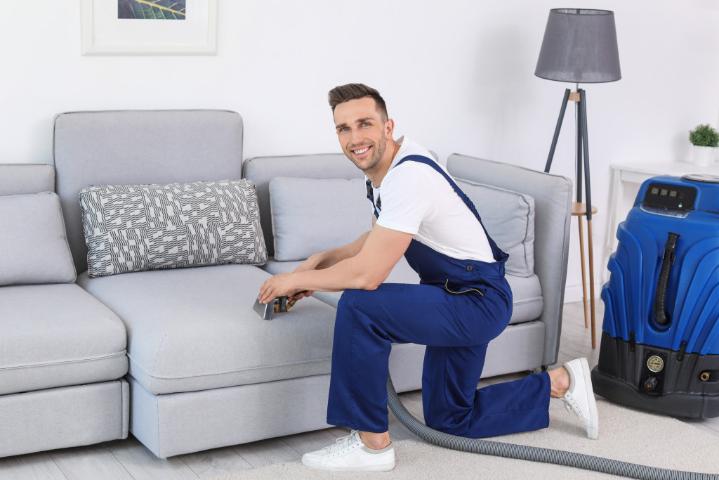 cleaning service man vacuuming the couch