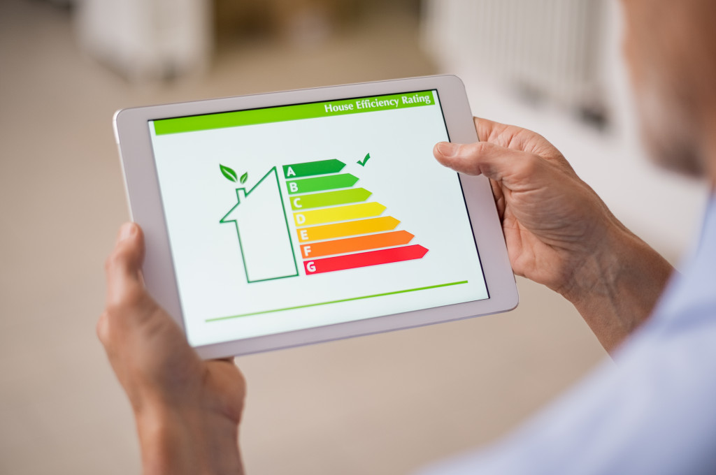 old man holding tablet with energy efficiency rating for their home